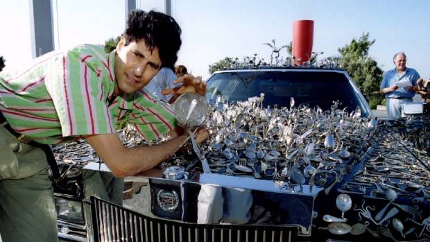 In this 1994 photo, once world-renowned psychic and spoon bender Uri Geller poses with his Cadillac and 5000 bent spoons. 